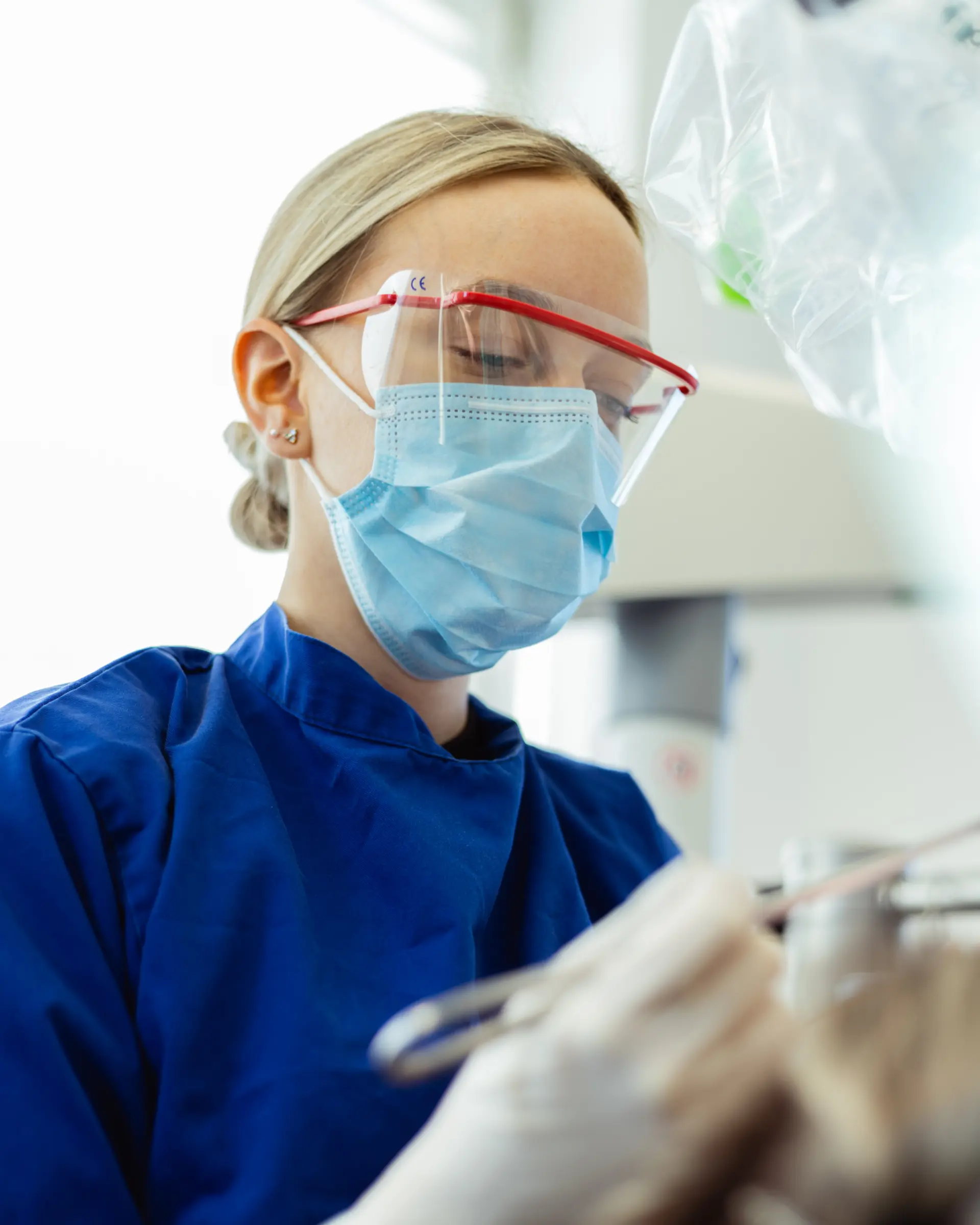 Mitarbeiterin während einer zahnmedizinischen Behandlung