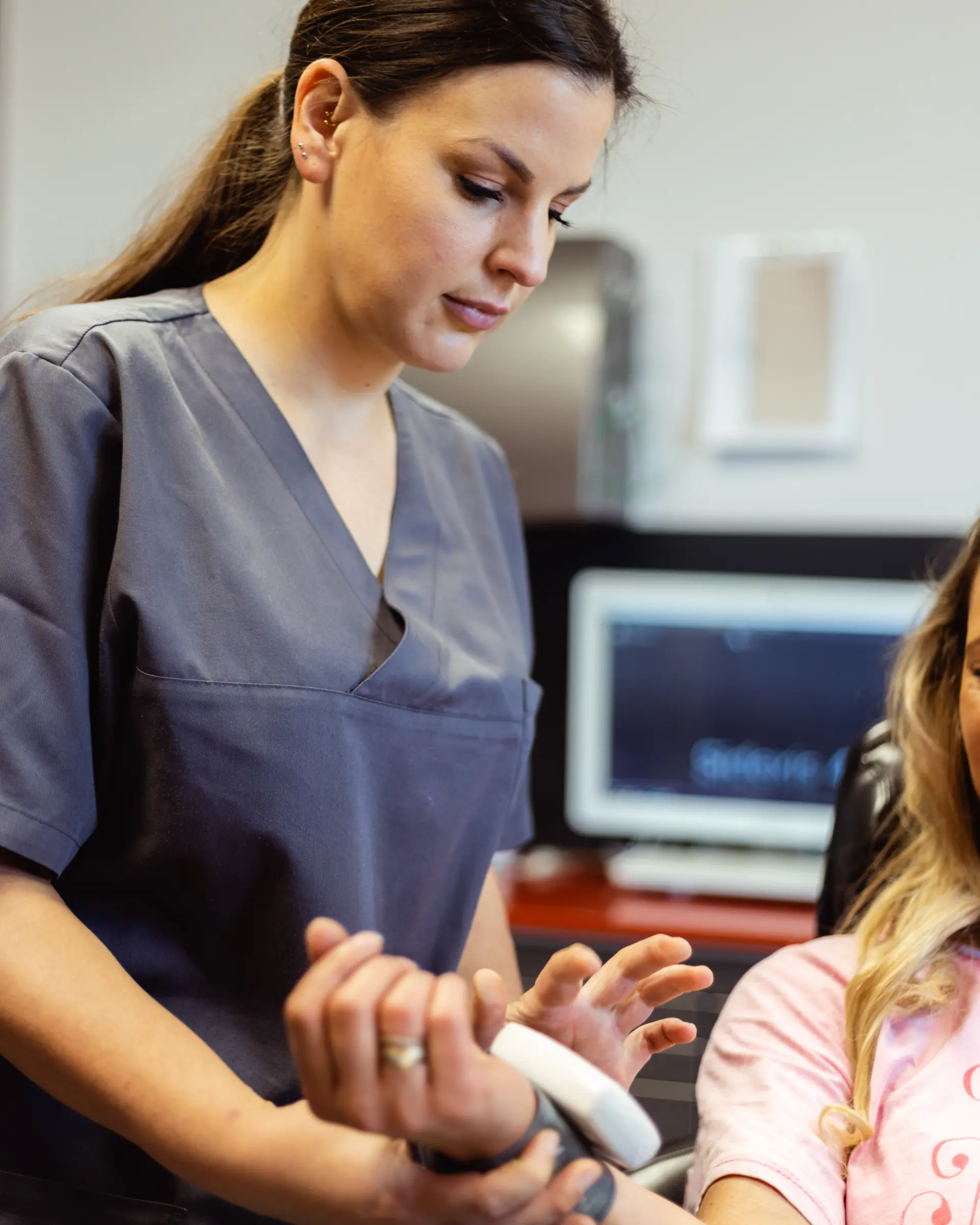 Mitarbeiterin führt einen digitalen Intraoralscan bei einer Patientin durch